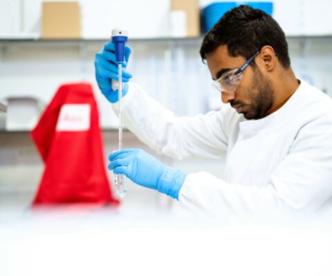Stagiaire adulte en Titre Pro Technicien de Laboratoire en train de remplir un tube à essai.